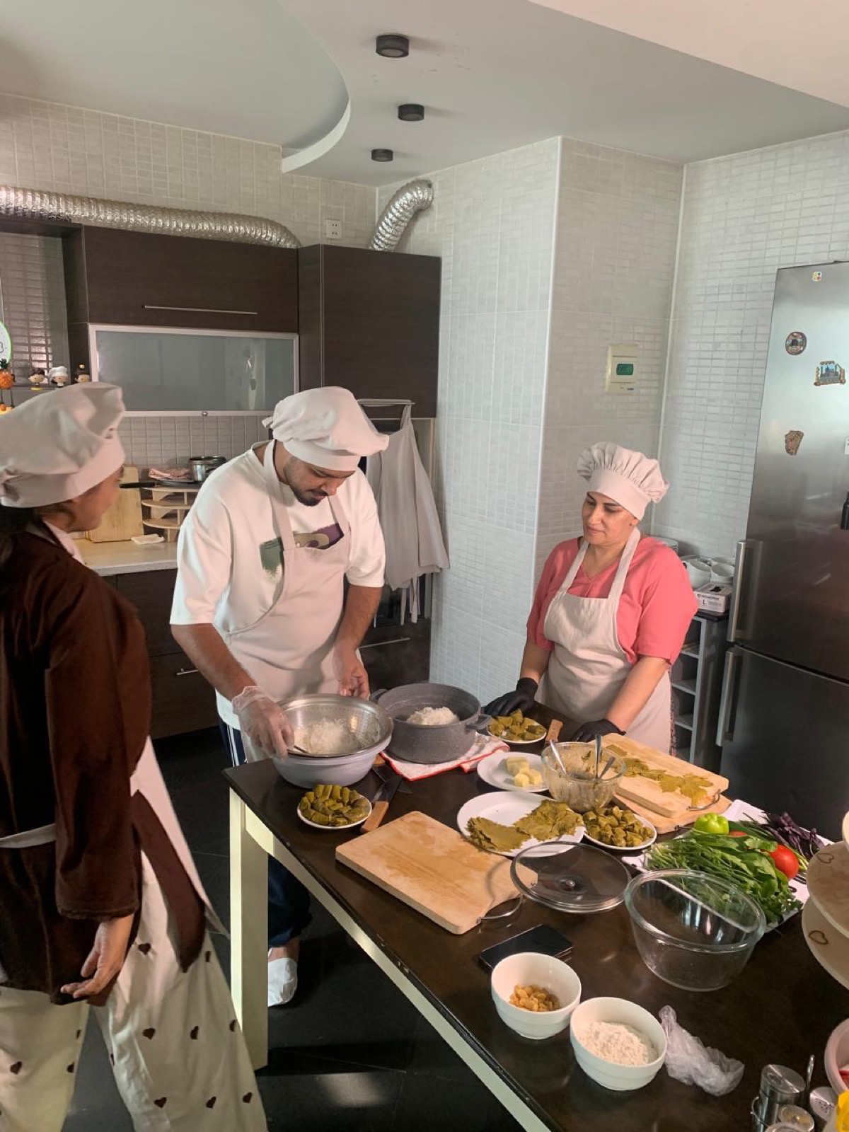 Private cooking class guests preparing Azerbaijani dishes in a Baku kitchen